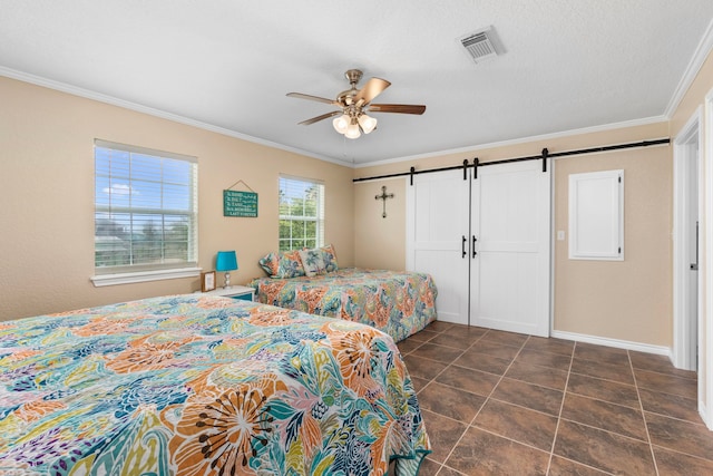 621 County Road 202, Sargent, TX 77414 - bedroom featuring a barn door, ornamental molding, dark tile patterned floors, baseboards, and a ceiling fan