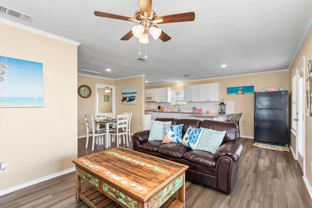621 County Road 202, Sargent, TX 77414 - living area featuring wood finished floors, ceiling fan, crown molding, baseboards, and recessed lighting