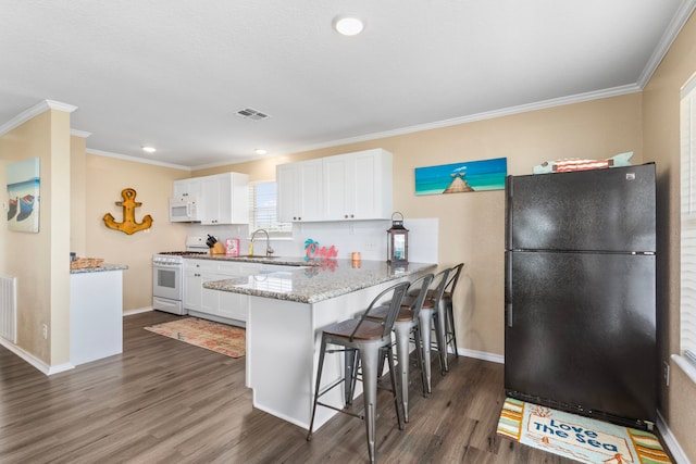 621 County Road 202, Sargent, TX 77414 - kitchen featuring white appliances, dark wood-style floors, white cabinetry, a breakfast bar, and crown molding