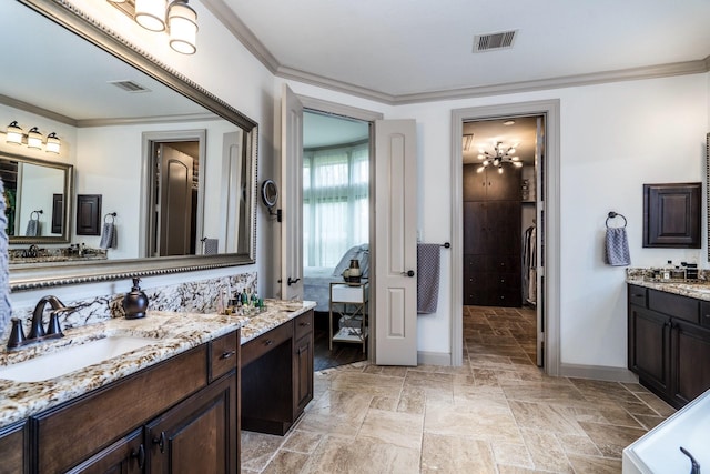 18815 Ellis Bend Dr, Cypress, TX 77433 - bathroom featuring two vanities, baseboards, crown molding, and stone tile flooring