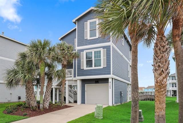 4123 King Rail Cir, Galveston, TX 77554 - beach home featuring a front yard, driveway, an attached garage, and stairs