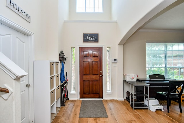 2818 Lakecrest Forest Dr, Katy, TX 77493 - foyer featuring wood finished floors, arched walkways, ornamental molding, a high ceiling, and baseboards
