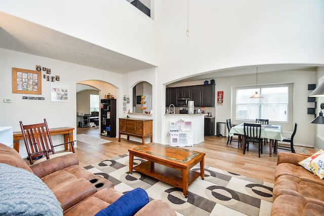 2818 Lakecrest Forest Dr, Katy, TX 77493 - living room featuring arched walkways and light wood-style floors