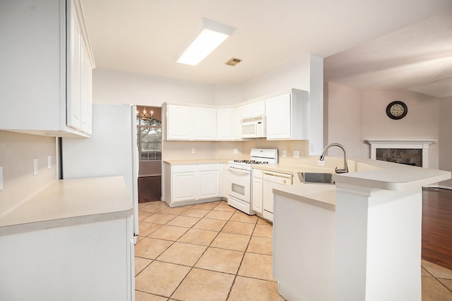 312 Cedar Branch Dr, League City, TX 77573 - kitchen featuring white appliances, a peninsula, light countertops, white cabinets, and light tile patterned flooring