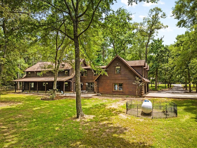 19314 Indigo Lake Dr, Magnolia, TX 77355 - rear view of property featuring log siding and a yard