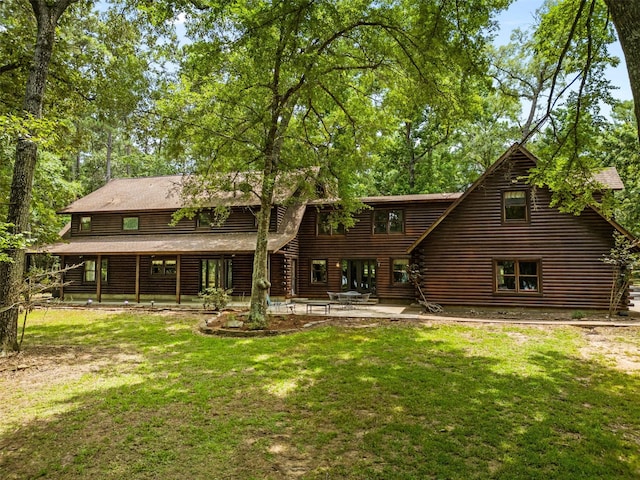 19314 Indigo Lake Dr, Magnolia, TX 77355 - back of property with log siding, a lawn, and a patio