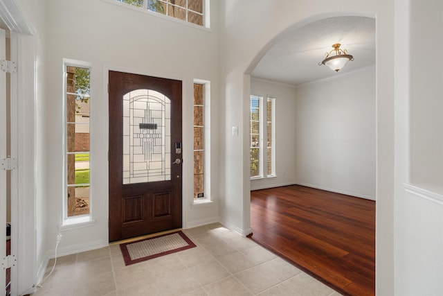 2113 Midway Ct, League City, TX 77573 - foyer with arched walkways, crown molding, light tile patterned floors, and baseboards