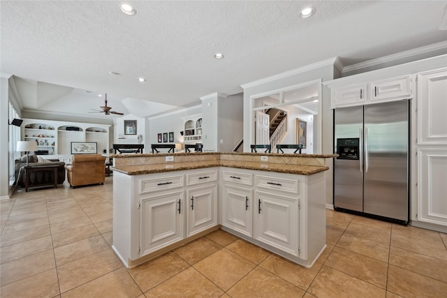 5902 Cardinal Creek Way, Kingwood, TX 77345 - kitchen with stainless steel refrigerator with ice dispenser, ornamental molding, light tile patterned flooring, ceiling fan, and open floor plan