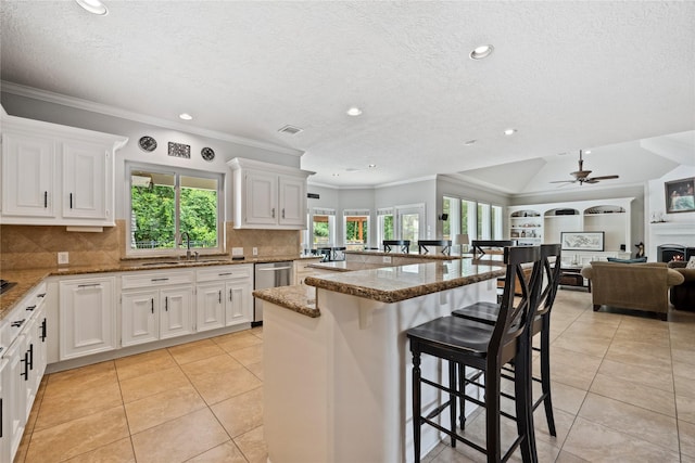 5902 Cardinal Creek Way, Kingwood, TX 77345 - kitchen featuring plenty of natural light, light tile patterned flooring, a kitchen breakfast bar, a textured ceiling, and dishwasher