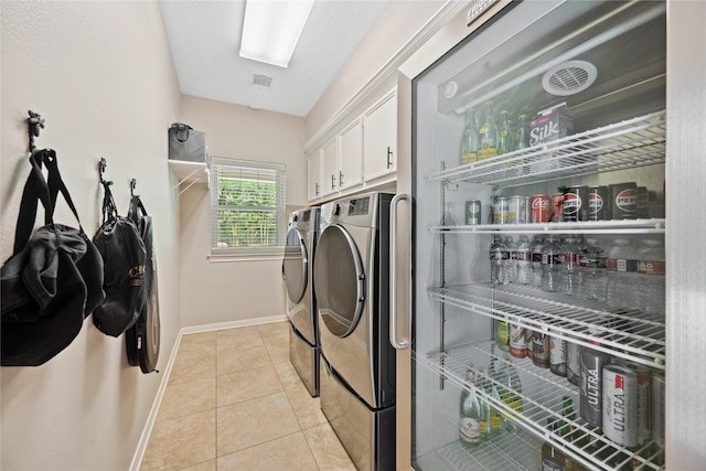5902 Cardinal Creek Way, Kingwood, TX 77345 - washroom with separate washer and dryer, cabinet space, baseboards, and light tile patterned floors