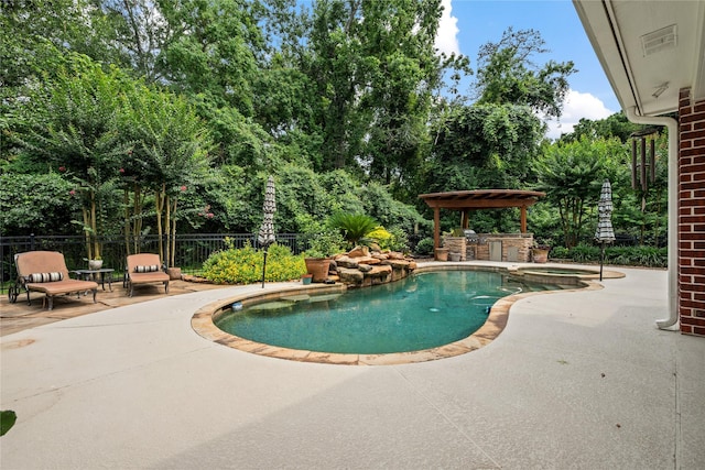 5902 Cardinal Creek Way, Kingwood, TX 77345 - view of pool with a patio area, a pool with connected hot tub, view of wooded area, and exterior kitchen