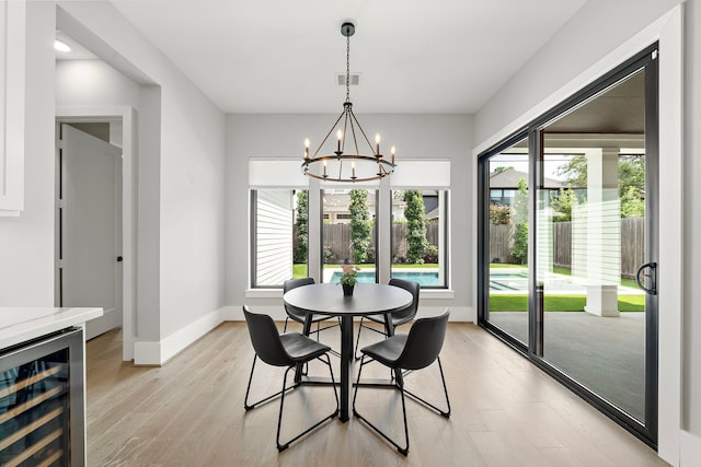 1610 Woodcrest Dr, Houston, TX 77018 - dining room with wine cooler, a chandelier, light wood-style flooring, and baseboards