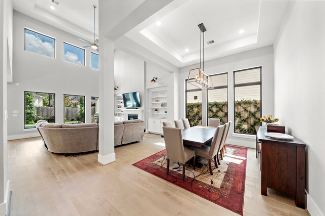 1610 Woodcrest Dr, Houston, TX 77018 - dining room featuring a tray ceiling, light wood finished floors, a ceiling fan, recessed lighting, and a high ceiling