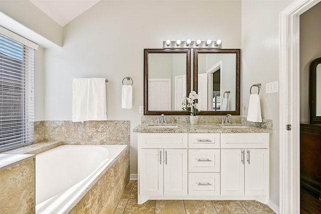 4506 Brazos Bend Dr, Pearland, TX 77584 - bathroom featuring double vanity, a bath, lofted ceiling, tile patterned floors, and baseboards
