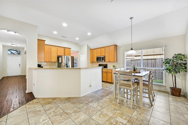 4506 Brazos Bend Dr, Pearland, TX 77584 - kitchen with appliances with stainless steel finishes, decorative backsplash, arched walkways, baseboards, and a peninsula