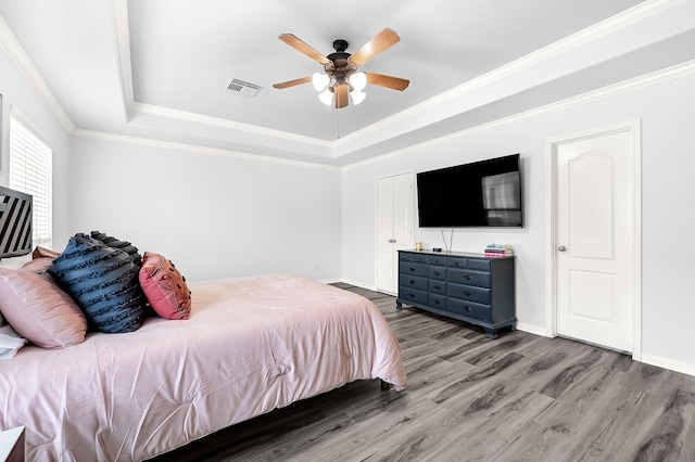 2602 Shady Acres Ct, Houston, TX 77008 - bedroom featuring a raised ceiling, wood finished floors, baseboards, a ceiling fan, and ornamental molding