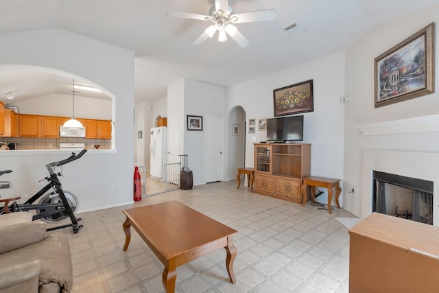 20207 Yellow Canyon Falls Dr, Tomball, TX 77375 - living room featuring vaulted ceiling, arched walkways, light floors, ceiling fan, and a fireplace