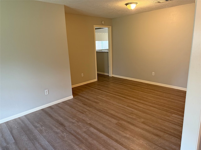 12819 Labelle Ln, Houston, TX 77015 - empty room featuring dark wood-type flooring, a textured ceiling, and baseboards