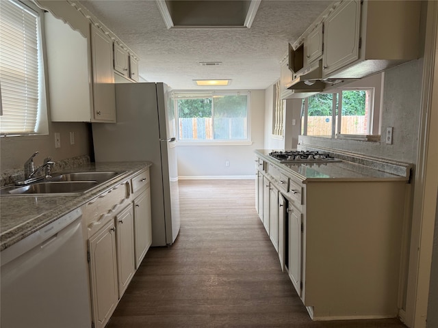 12819 Labelle Ln, Houston, TX 77015 - kitchen with white dishwasher, a sink, dark wood-style flooring, a textured ceiling, and stainless steel gas stovetop