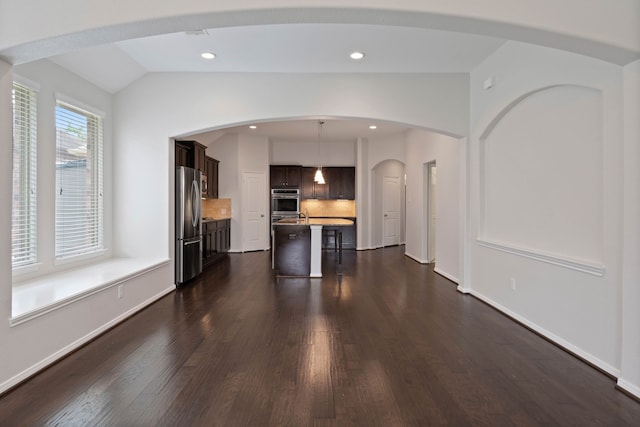 253 Dove Meadow Dr, Conroe, TX 77384 - kitchen with appliances with stainless steel finishes, dark brown cabinets, a kitchen breakfast bar, dark wood-style floors, and light countertops