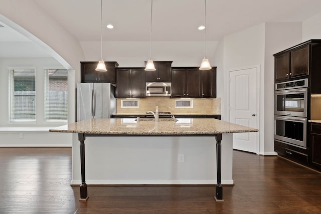 253 Dove Meadow Dr, Conroe, TX 77384 - kitchen featuring appliances with stainless steel finishes, decorative backsplash, a breakfast bar, light stone counters, and recessed lighting