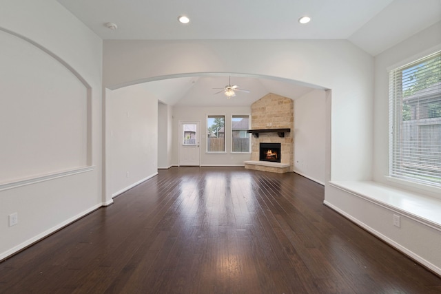 253 Dove Meadow Dr, Conroe, TX 77384 - unfurnished living room featuring vaulted ceiling, a ceiling fan, healthy amount of natural light, wood finished floors, and a stone fireplace