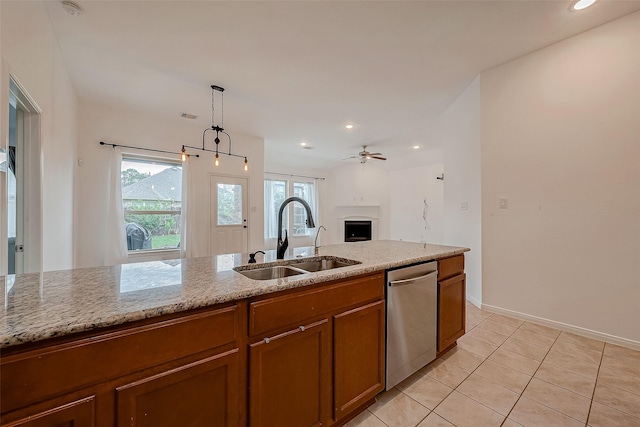 5339 Glenfield Spring Ln, Spring, TX 77389 - kitchen with a sink, stainless steel dishwasher, brown cabinetry, light stone counters, and open floor plan