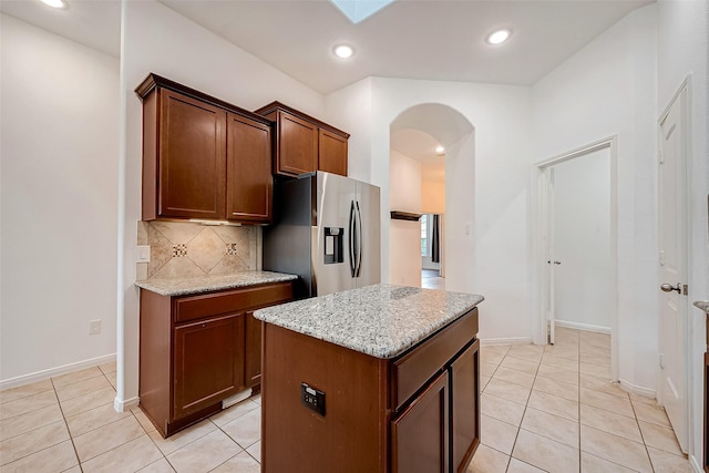 5339 Glenfield Spring Ln, Spring, TX 77389 - kitchen with stainless steel refrigerator with ice dispenser, arched walkways, light tile patterned flooring, decorative backsplash, and recessed lighting