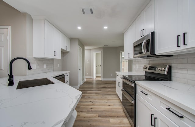 5238 Timber Quail Dr, Humble, TX 77346 - kitchen with stainless steel appliances, a sink, recessed lighting, backsplash, and light wood-type flooring