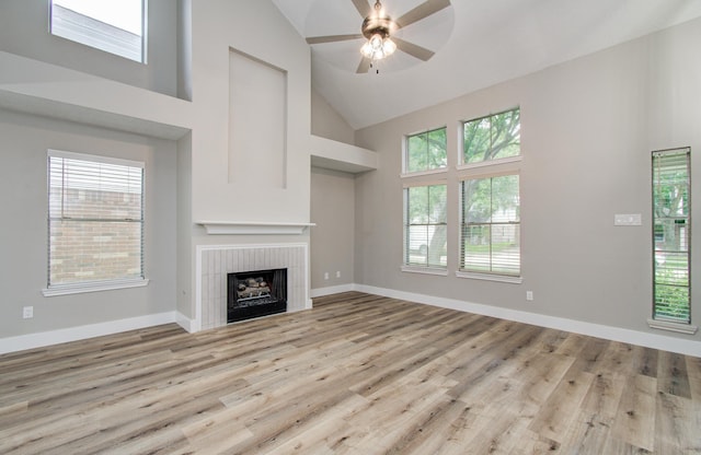 5238 Timber Quail Dr, Humble, TX 77346 - unfurnished living room featuring high vaulted ceiling, a tiled fireplace, wood finished floors, ceiling fan, and baseboards