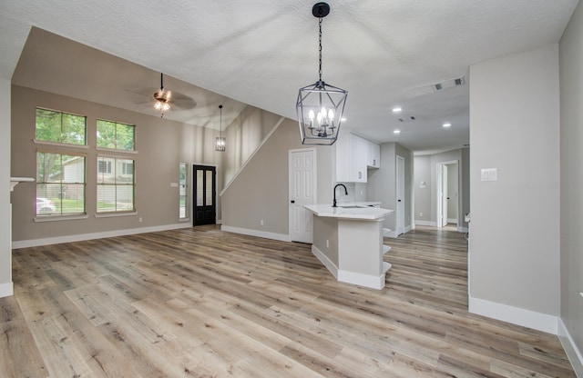 5238 Timber Quail Dr, Humble, TX 77346 - kitchen with open floor plan, a sink, light countertops, a ceiling fan, and white cabinets