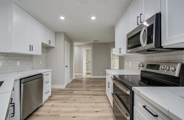 5238 Timber Quail Dr, Humble, TX 77346 - kitchen with stainless steel appliances, baseboards, white cabinets, light wood finished floors, and recessed lighting