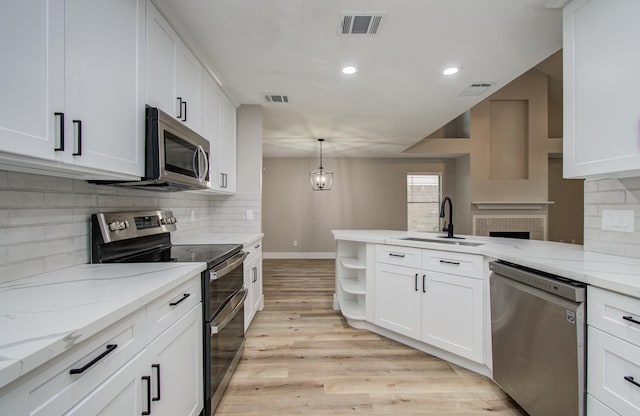 5238 Timber Quail Dr, Humble, TX 77346 - kitchen with stainless steel appliances, a sink, white cabinetry, a peninsula, and tasteful backsplash