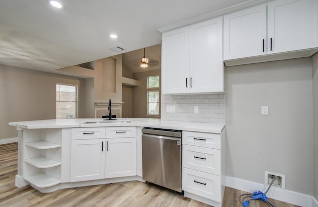 5238 Timber Quail Dr, Humble, TX 77346 - kitchen featuring stainless steel dishwasher, a sink, a peninsula, open shelves, and baseboards