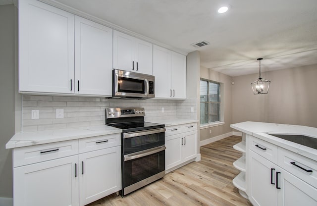 5238 Timber Quail Dr, Humble, TX 77346 - kitchen featuring appliances with stainless steel finishes, backsplash, white cabinets, light wood-style floors, and baseboards