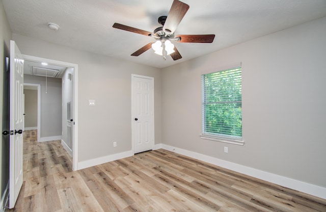 5238 Timber Quail Dr, Humble, TX 77346 - unfurnished bedroom featuring attic access, light wood-type flooring, baseboards, ceiling fan, and a closet