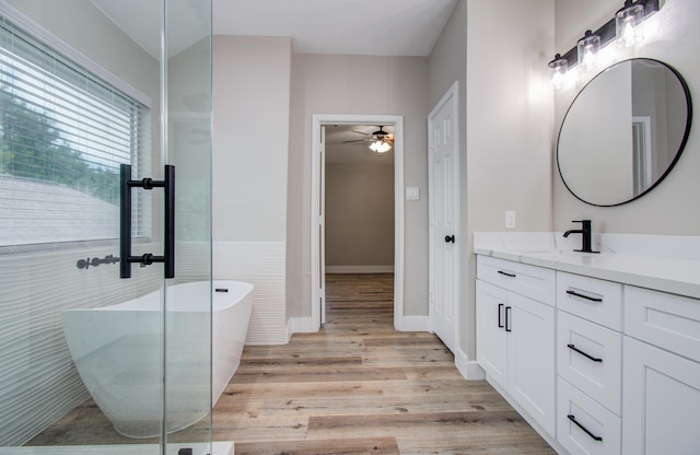 5238 Timber Quail Dr, Humble, TX 77346 - full bathroom featuring vanity, a freestanding tub, wood finished floors, a ceiling fan, and baseboards