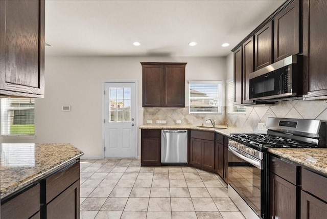 2114 Sand Ridge Dr, Texas City, TX 77568 - kitchen featuring stainless steel appliances, a sink, backsplash, dark brown cabinets, and recessed lighting