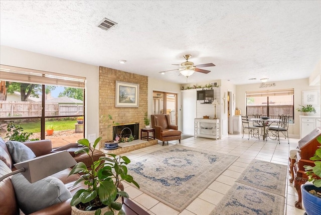 2639 Valley Field Dr, Sugar Land, TX 77479 - tiled living area with ceiling fan, a brick fireplace, and a textured ceiling