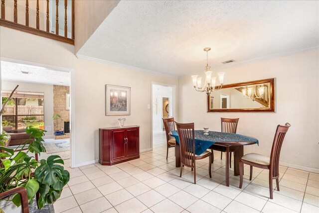 2639 Valley Field Dr, Sugar Land, TX 77479 - dining room with a chandelier, ornamental molding, light tile patterned flooring, baseboards, and a textured ceiling