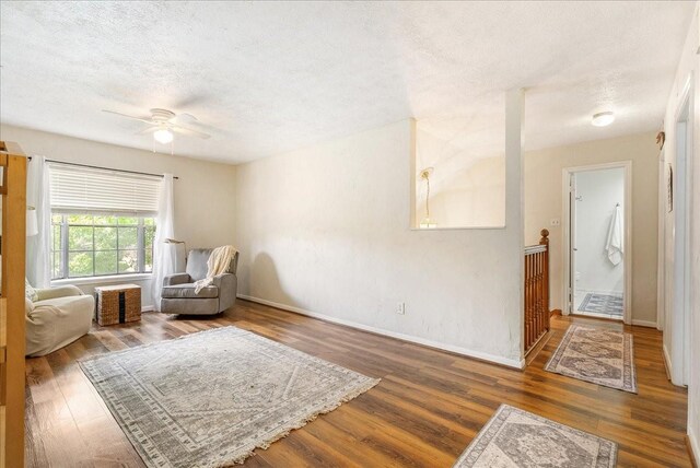 2639 Valley Field Dr, Sugar Land, TX 77479 - living area with wood finished floors, a textured ceiling, a ceiling fan, and baseboards