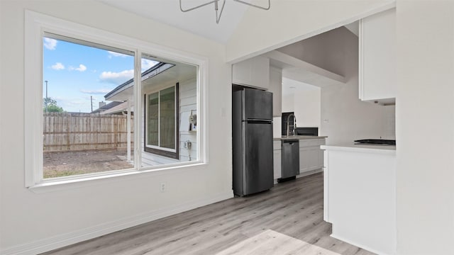 24006 Scrivener Ln, Katy, TX 77493 - kitchen with appliances with stainless steel finishes, white cabinets, plenty of natural light, light wood-style floors, and vaulted ceiling