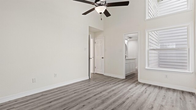 24006 Scrivener Ln, Katy, TX 77493 - spare room with light wood-style floors, a ceiling fan, baseboards, and a towering ceiling