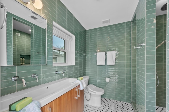 2101 Banks St, Houston, TX 77098 - bathroom featuring tile walls, toilet, tiled shower, vanity, and tile patterned flooring