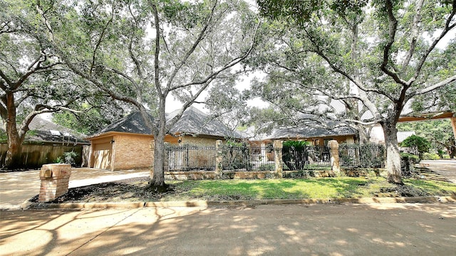 19823 Sunbridge Ln, Houston, TX 77094 - view of front of home featuring a fenced front yard, concrete driveway, brick siding, and a garage