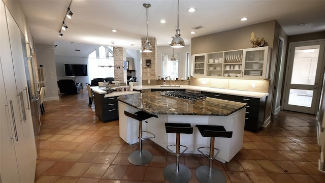19823 Sunbridge Ln, Houston, TX 77094 - kitchen with stainless steel gas stovetop, a kitchen bar, a sink, a center island, and backsplash