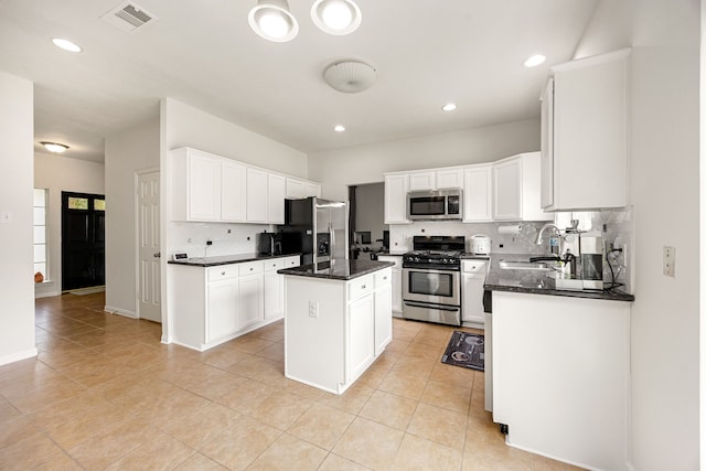 17823 Scenic Oaks Dr, Richmond, TX 77407 - kitchen with appliances with stainless steel finishes, a sink, backsplash, light tile patterned floors, and a center island