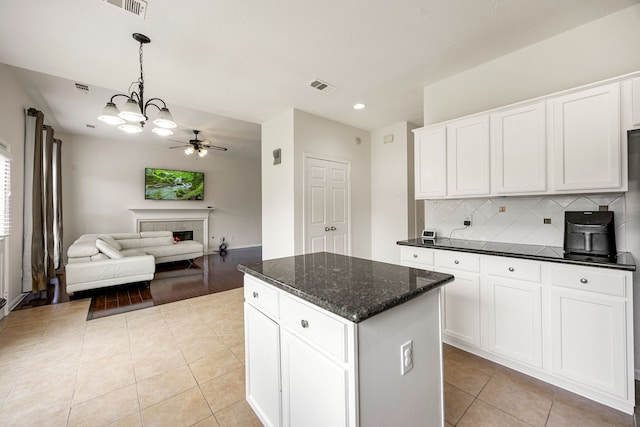 17823 Scenic Oaks Dr, Richmond, TX 77407 - kitchen with a center island, open floor plan, ceiling fan, light tile patterned floors, and decorative backsplash