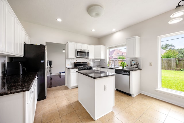 17823 Scenic Oaks Dr, Richmond, TX 77407 - kitchen featuring appliances with stainless steel finishes, a sink, tasteful backsplash, a kitchen island, and white cabinets