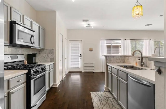 1609 Palcio Real Dr, Houston, TX 77047 - kitchen with appliances with stainless steel finishes, a sink, gray cabinets, decorative backsplash, and light countertops